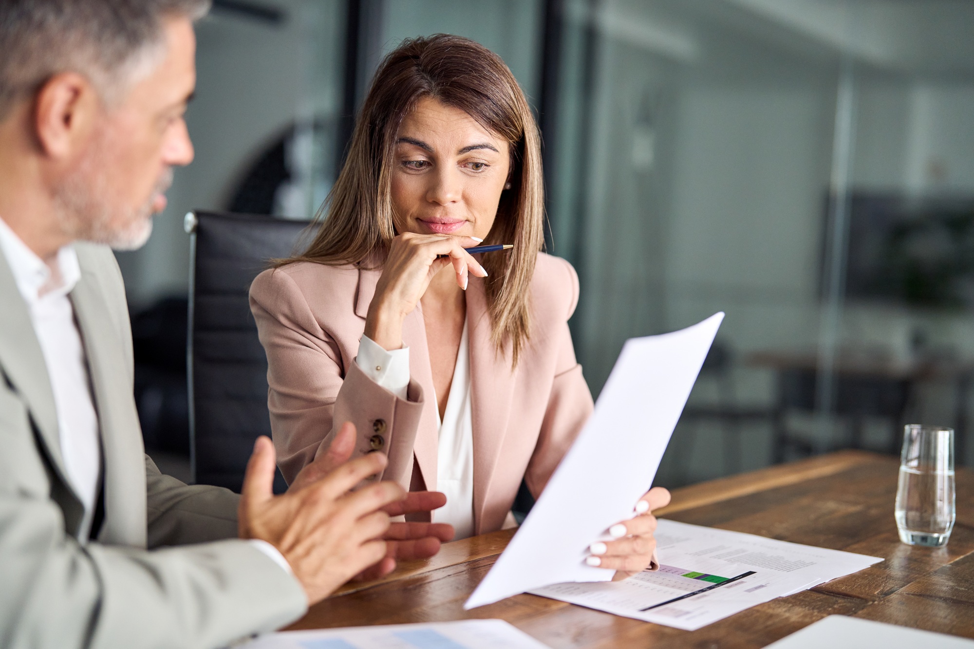 Two financial experts discussing accounting tax documents in office.